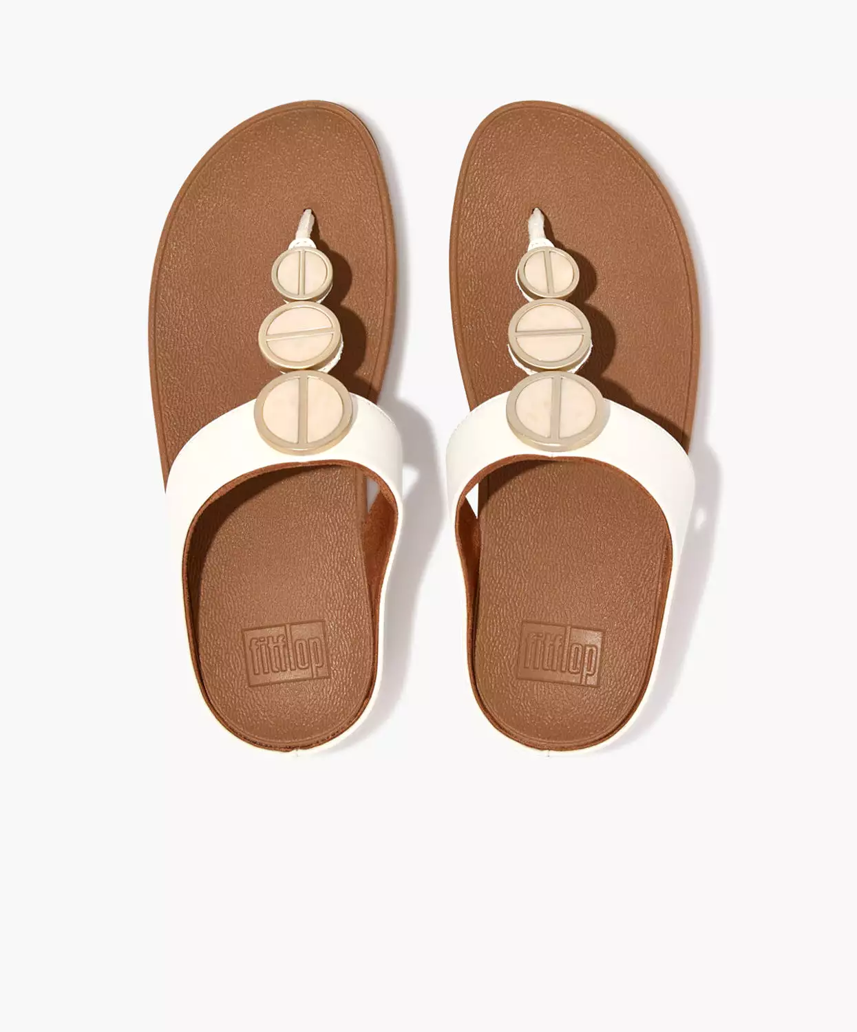 FitFlop sandals with metallic trim and toe post in cream color.